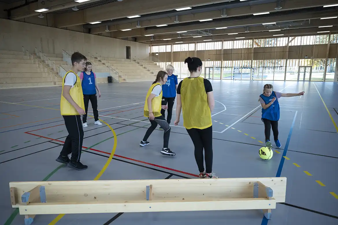 En skoleklasse spiller hjørnefotball i gymsalen