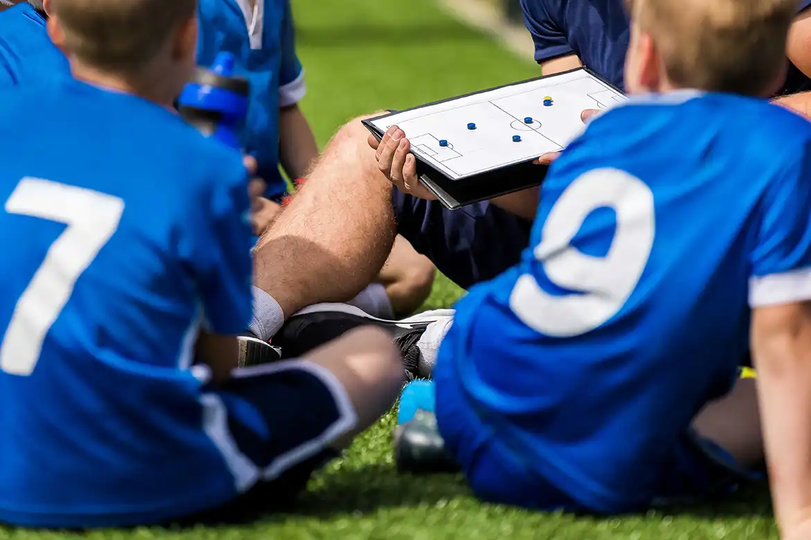 Fotballtrener viser frem fotballtaktikk på en taktikktavle