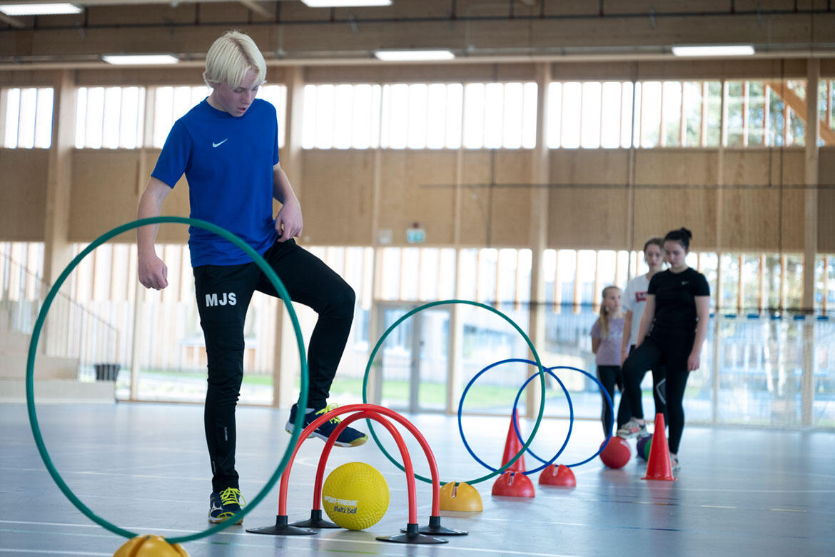 Barn som spiller Fotballkrokket i kroppsøvingstimen innendørs