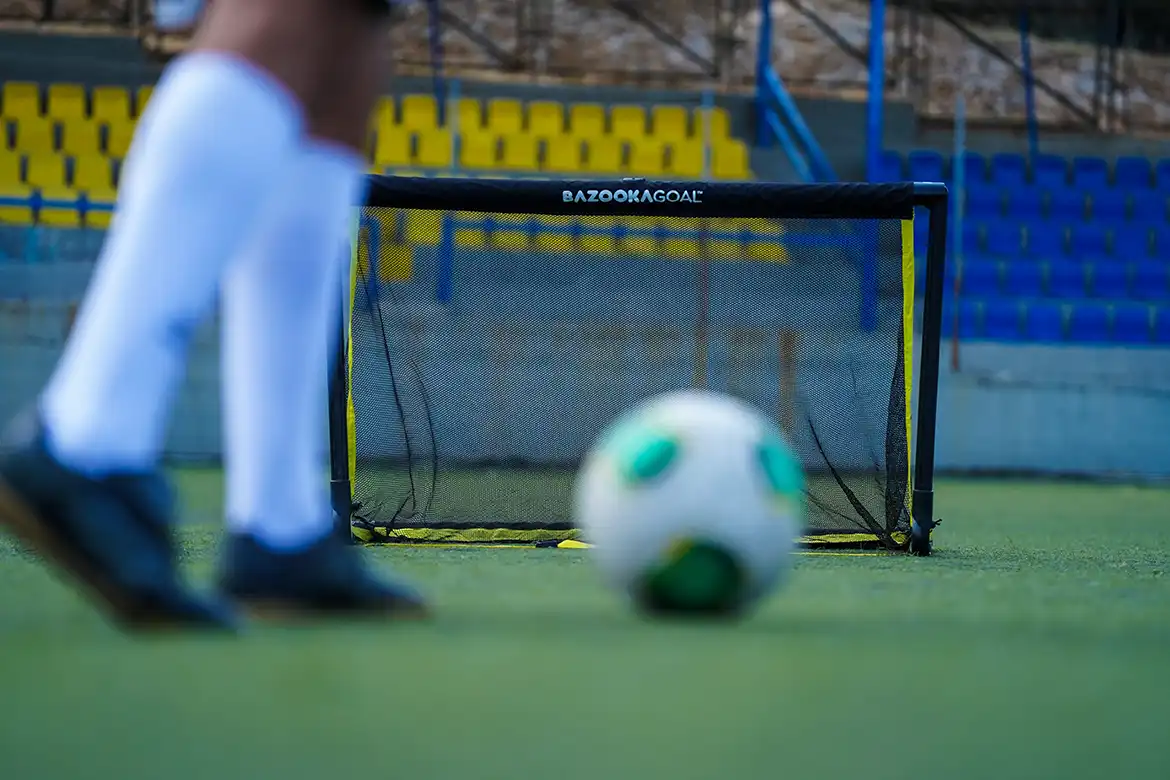 En fotballspiller som skyter fotballen mot et BazookaGoal XL