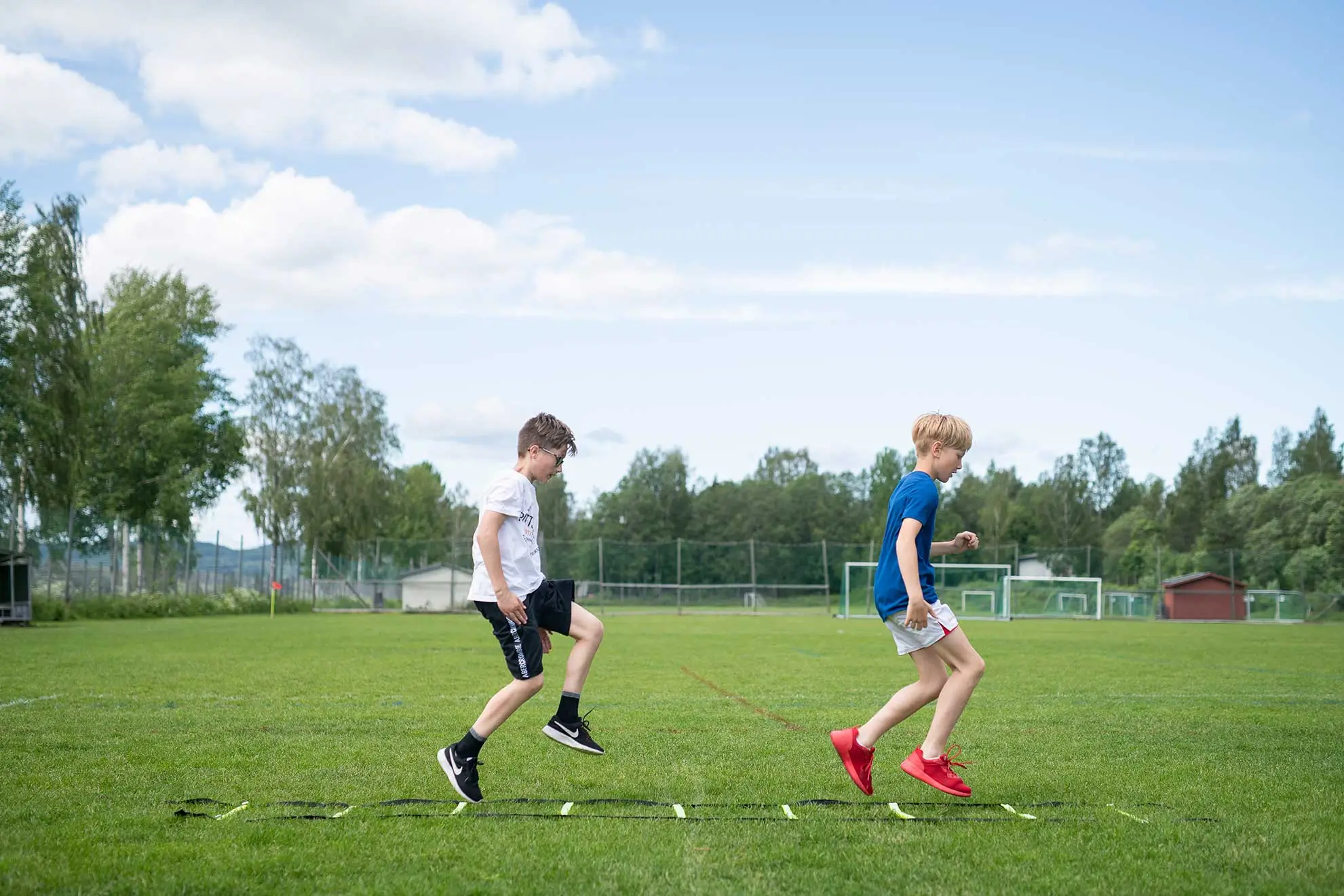 To gutter som trener fotball utendørs