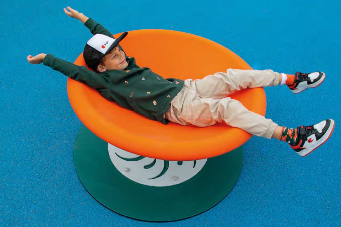 Gutt som snurrer rundt på en lekeplasskarusell