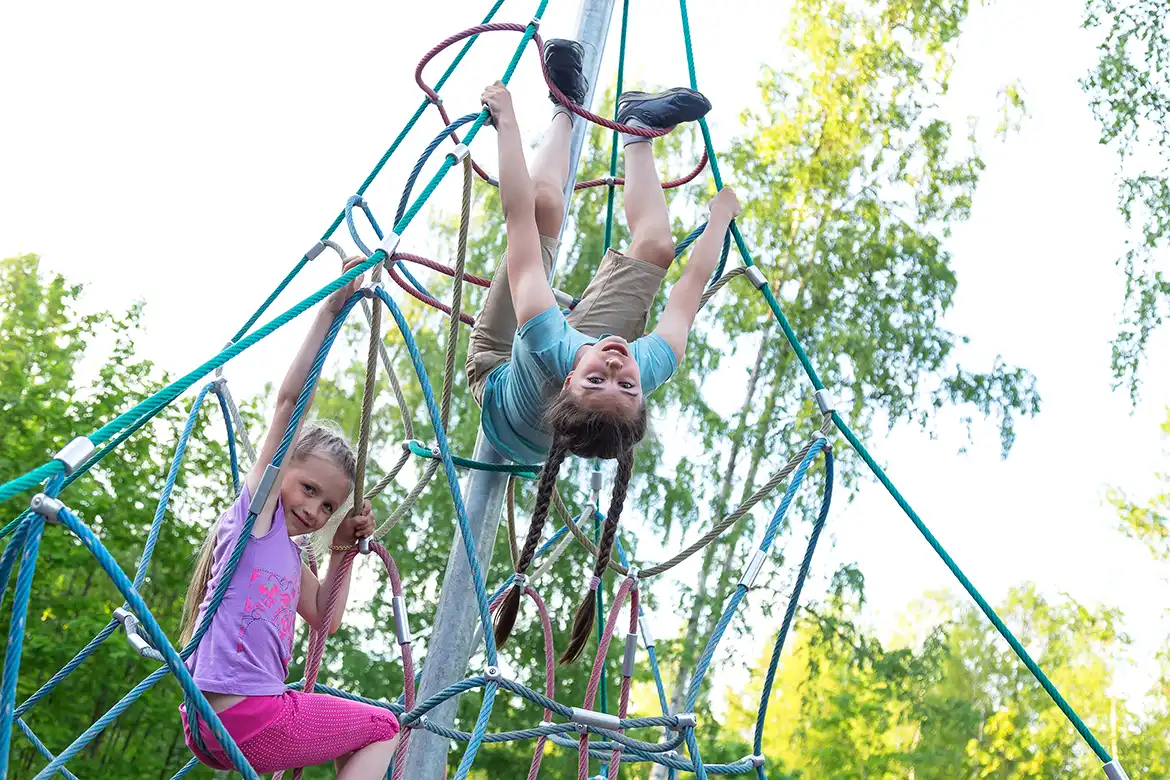 Barn som leker i et klatrenett utendørs
