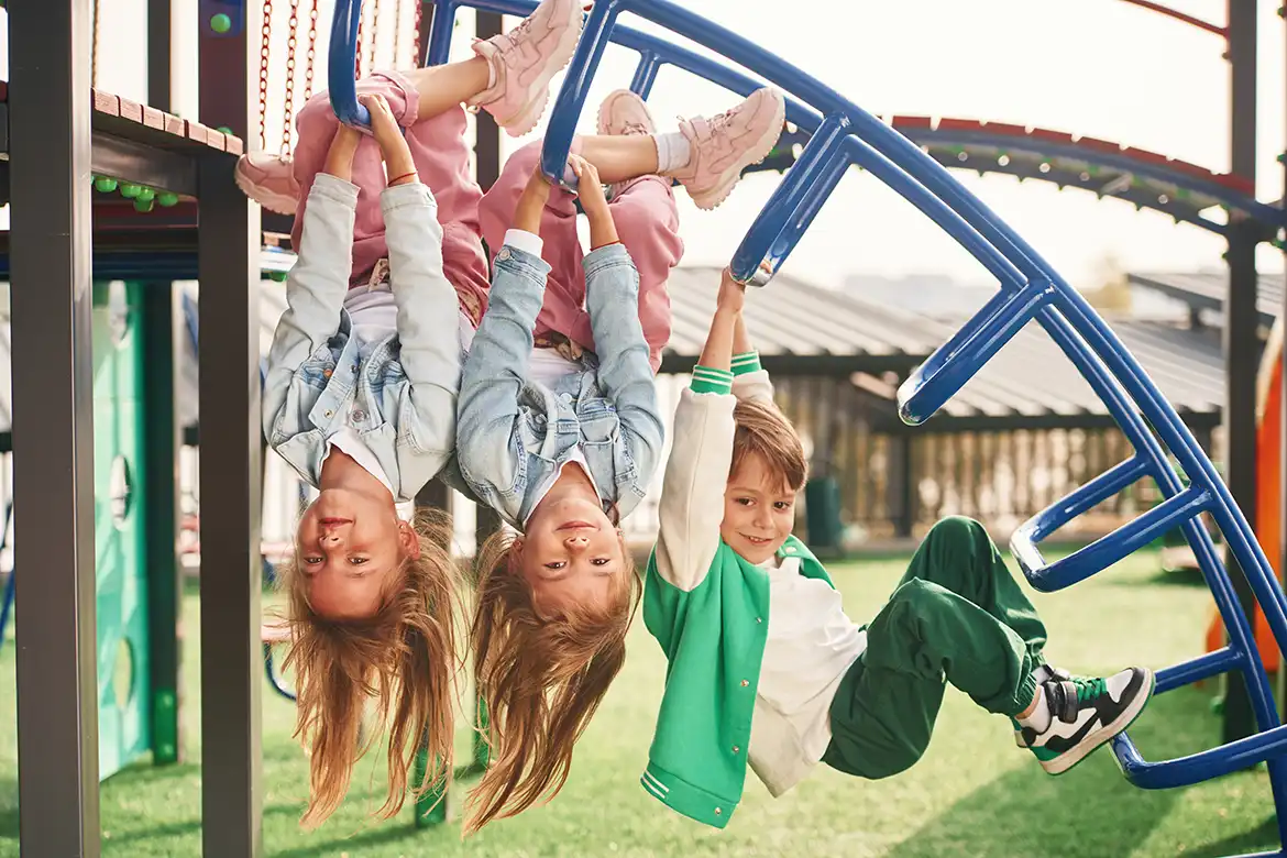 Glade barn klatrer rundt i et lekestativ utendørs