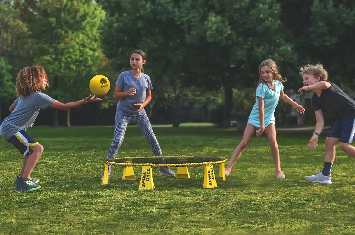 Barn som spiller Spikeball utendørs om sommeren