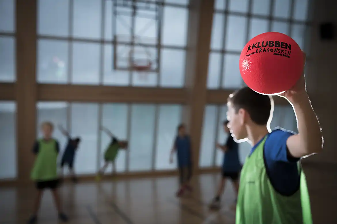 En skoleklasse som spiller stikkball_kanonball i kroppsøvingstimen innendørs