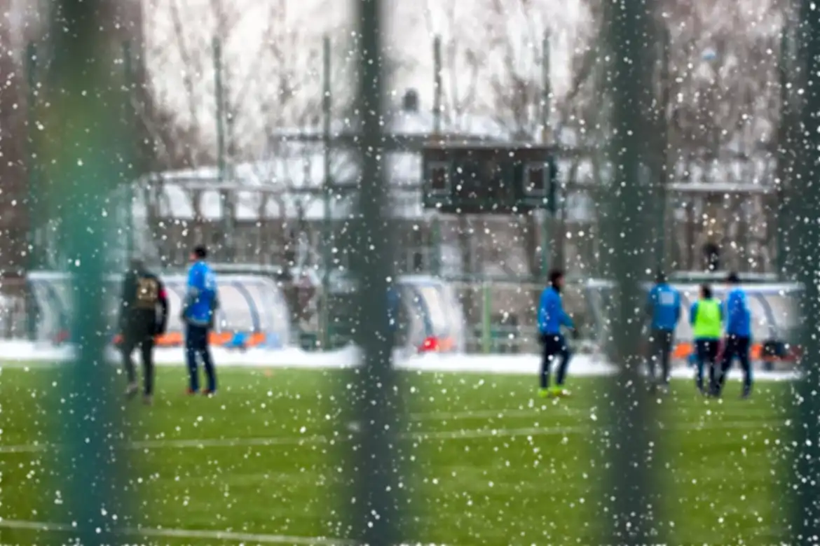 Fotballtrening utendørs på vinteren, det snør