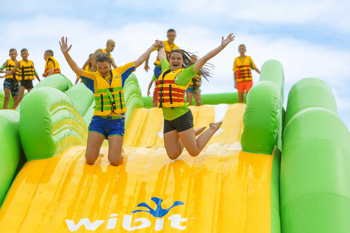 Barn som leker i en vannhinderløype (Wibit SportsPark) utendørs